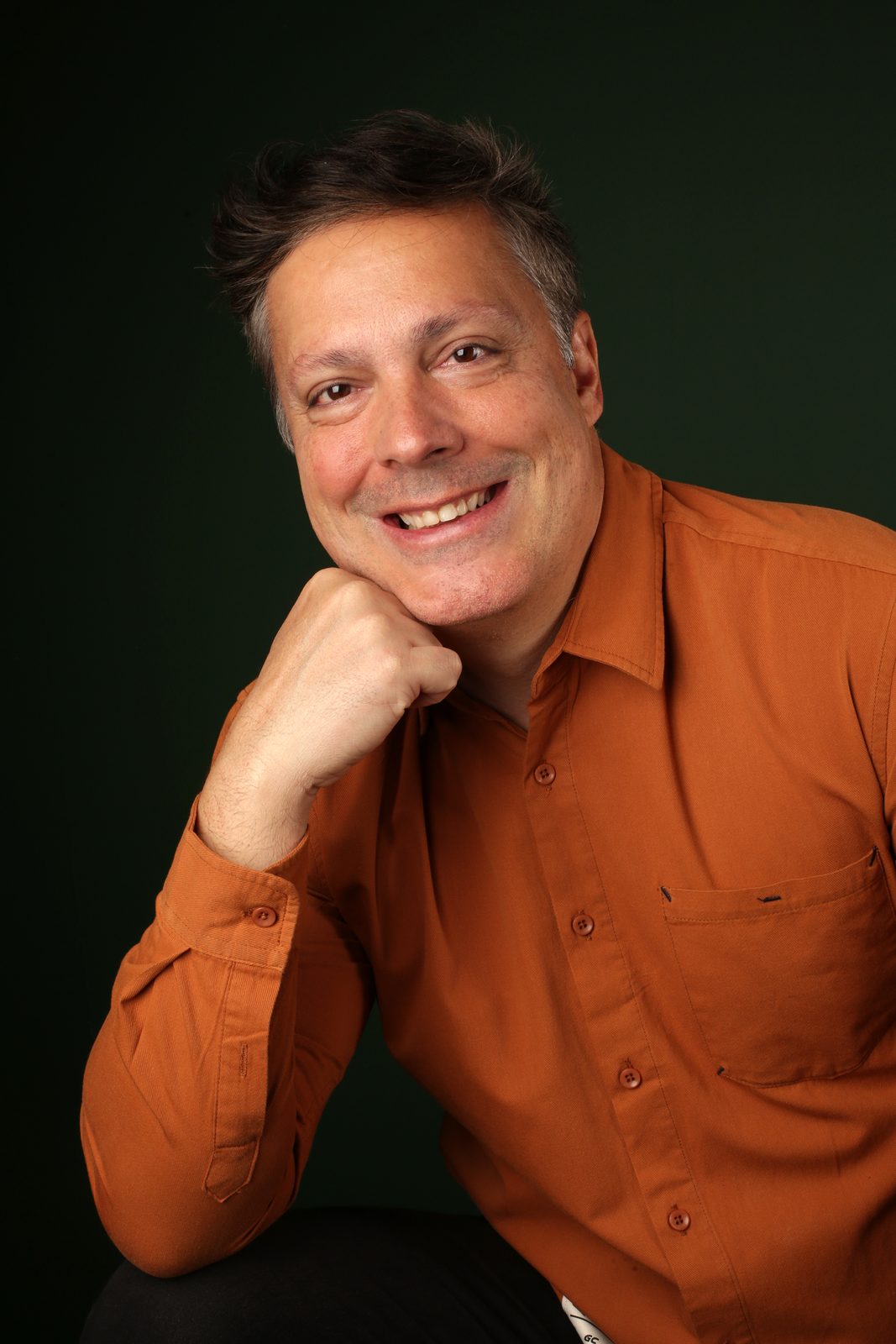 Eduardo Lassah, ator, sorrindo em retrato para publicidade